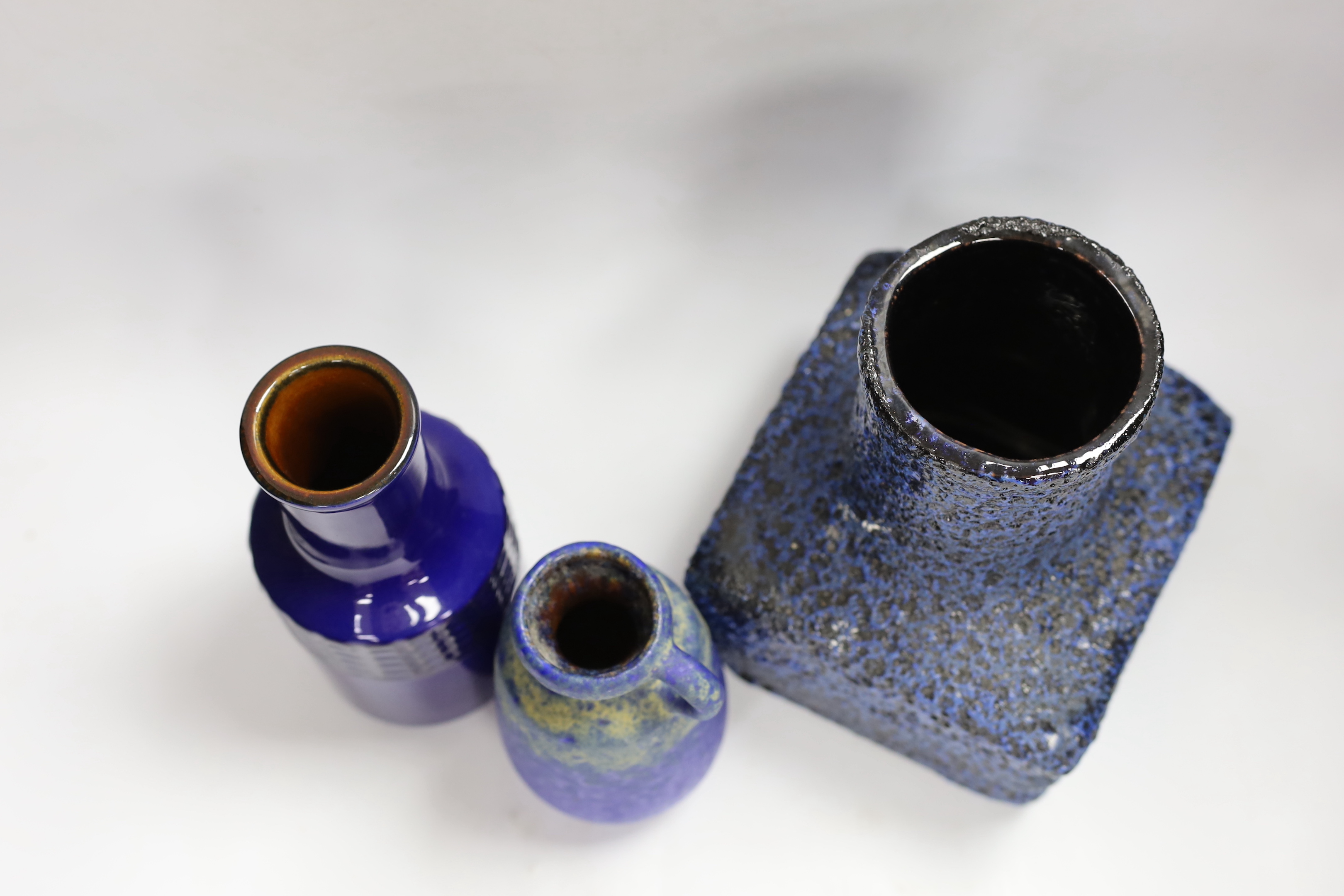 Three West German pottery vases in blue ground, one with lava glaze, tallest 22cm